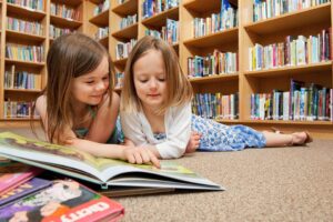 dekleti bereta knjigo v knjižnici